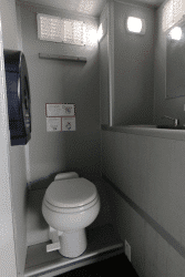 Vista interior de baño portátil VIP con sanitario, lavabo y acabados funcionales.